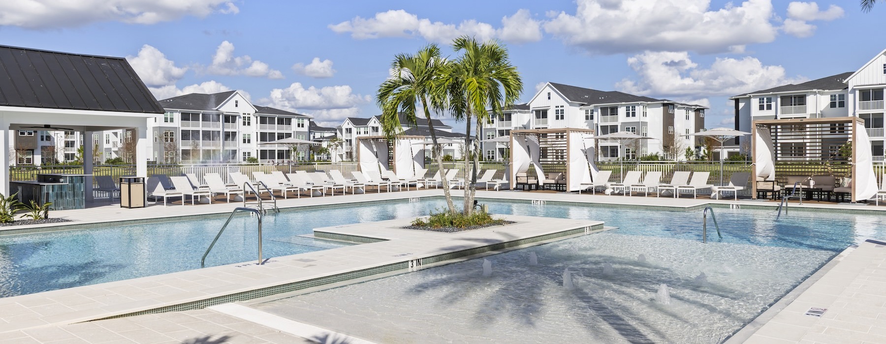 a pool with palm trees and lounge chairs