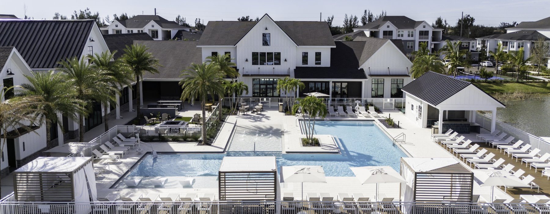 a courtyard with a pool and lounge chairs